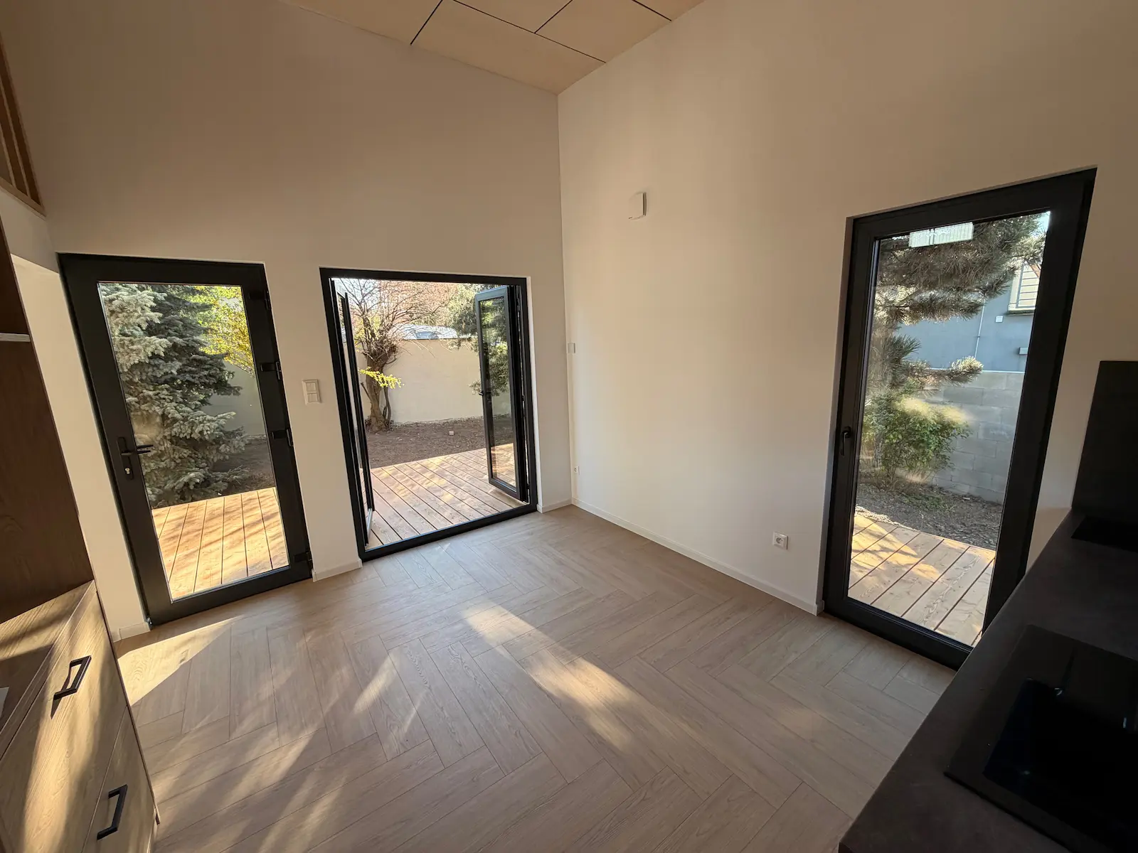 Obytná místnost malého domu LOFT 33 s prosklenými dveřmi na terasu